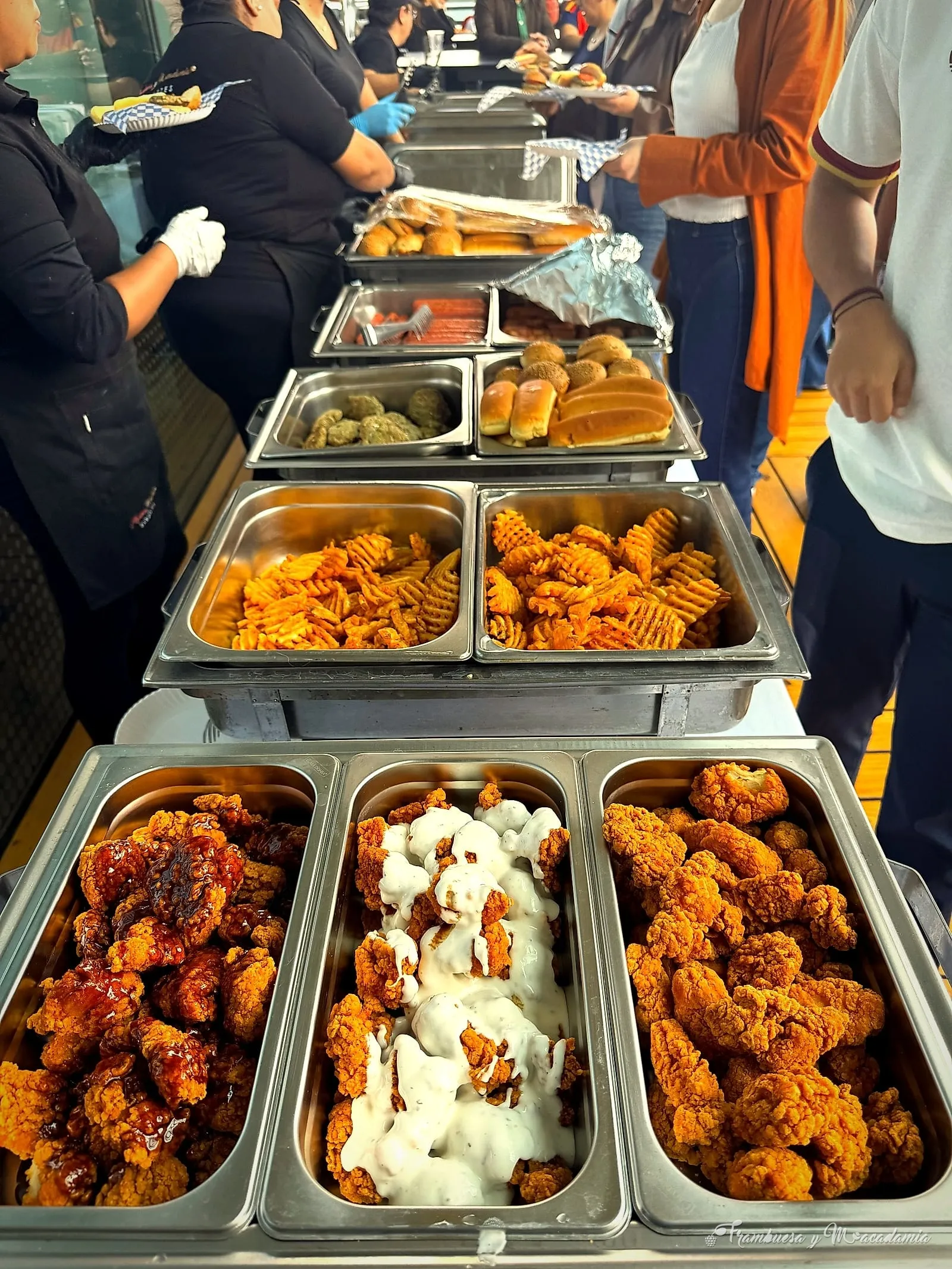 Buffet de comida americana servido en evento: boneless, papas waffle y panes