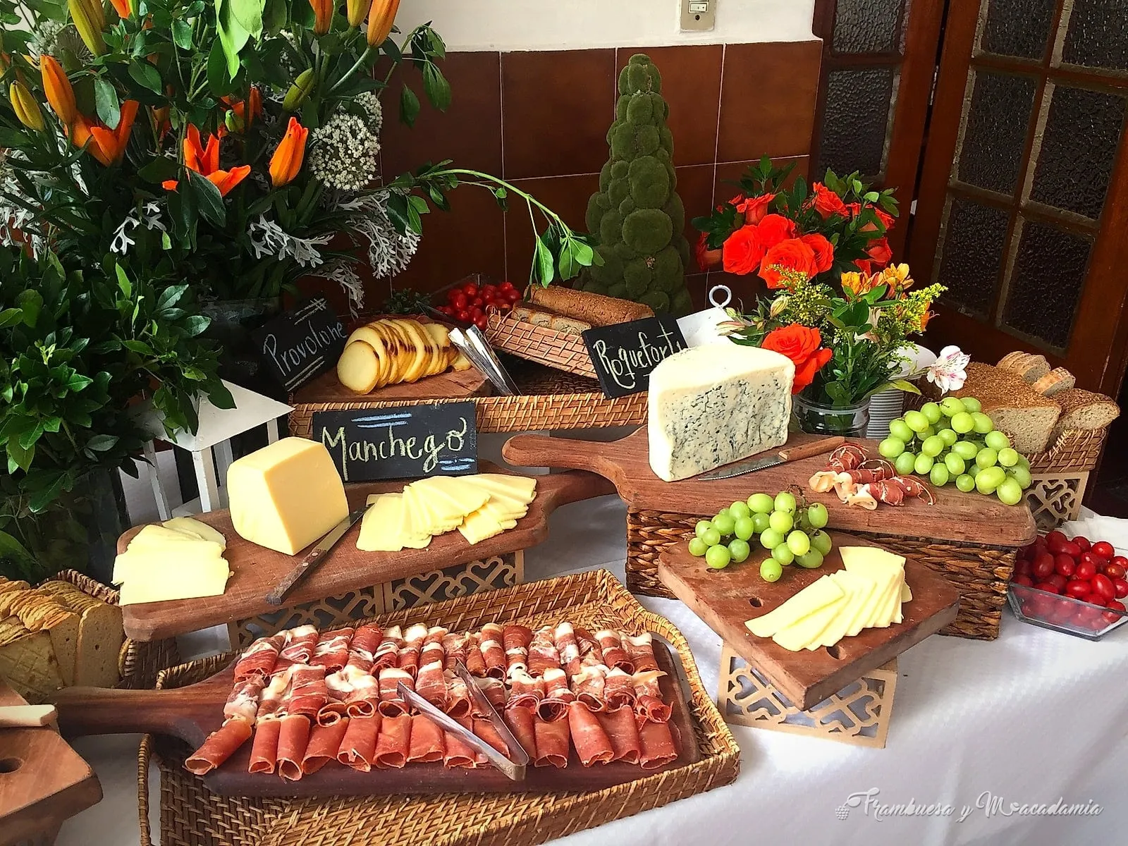 Mesa de banquete con quesos, carnes frías y panes artesanales