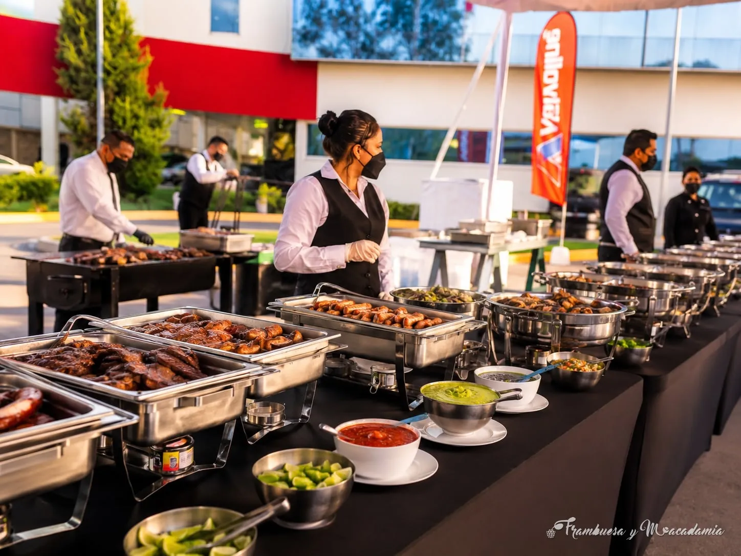 Línea de buffet de parrillada con personal de servicio en evento corporativo