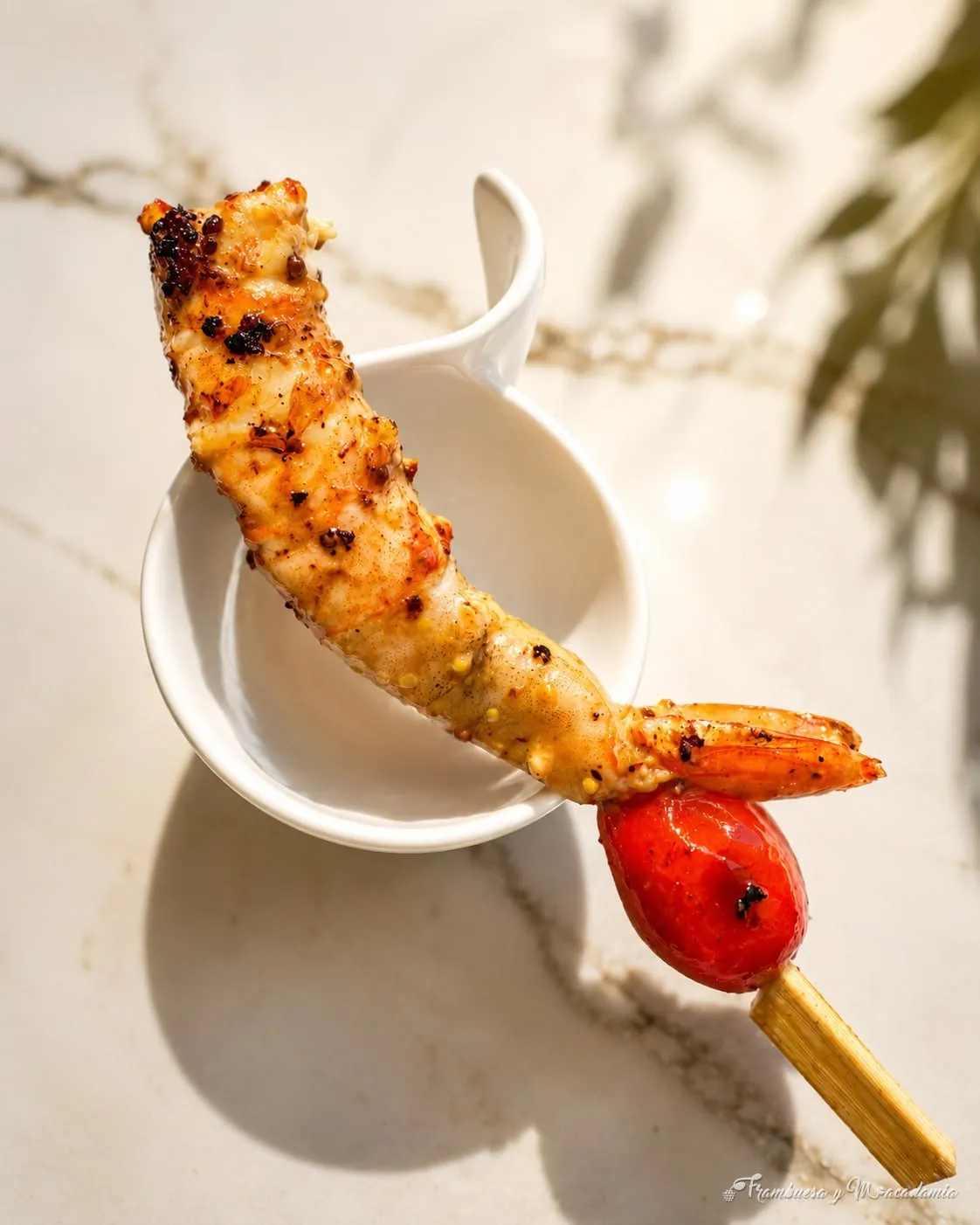 Brocheta de camarón al grill servida sobre taza individual
