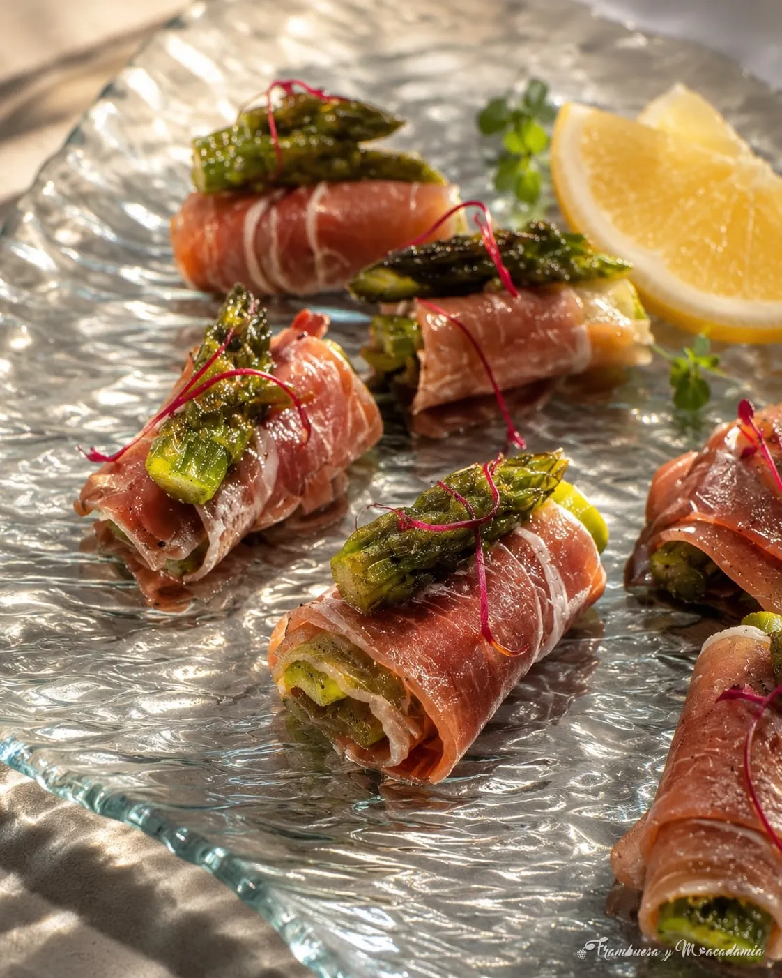 Envueltos de jamón serrano con espárragos y taratoor sobre plato de cristal