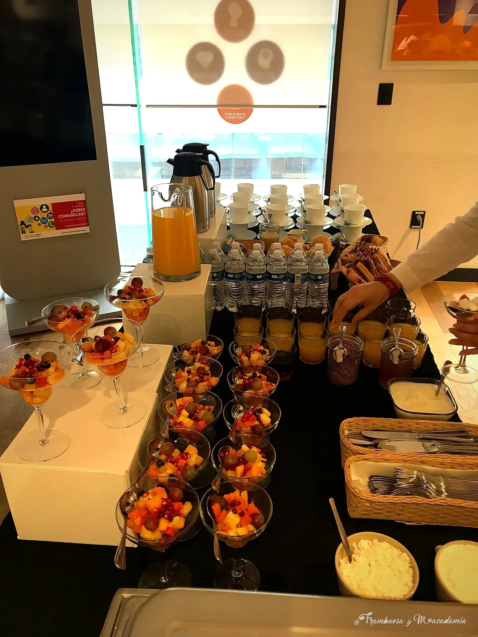 Copas de fruta fresca, jugos y yogurt en montaje de coffee break