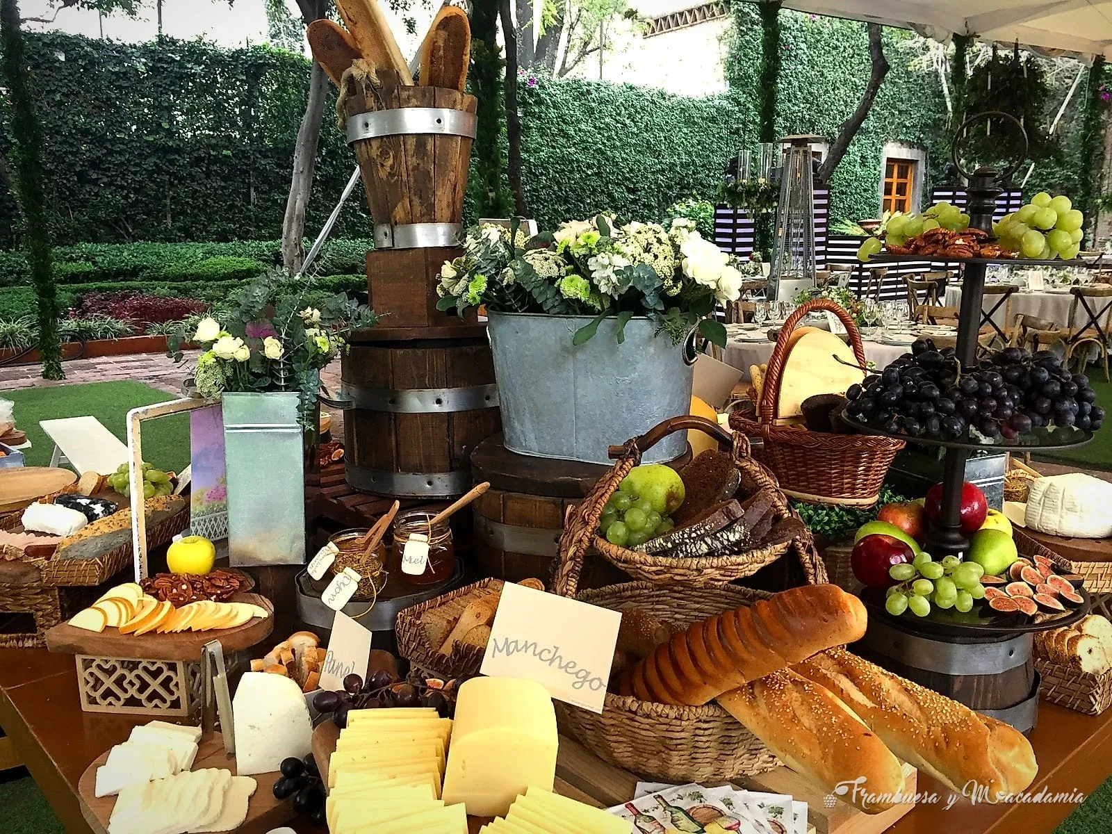 Mesa de quesos montada en jardín de salón de eventos
