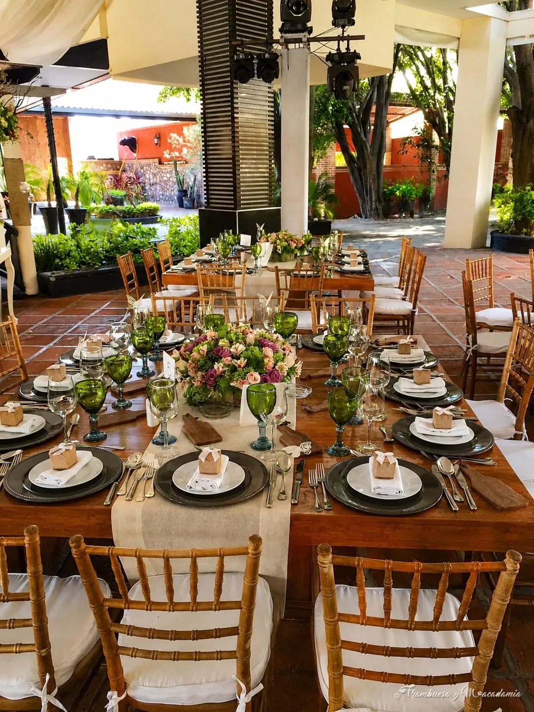 Mesa rectangular con sillas cross back, vajilla y centro de flores en terraza