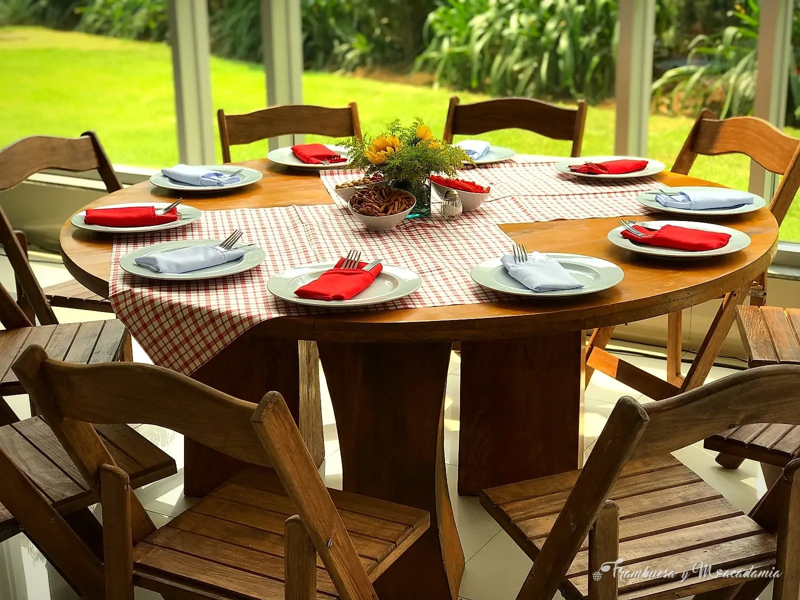 Mesa redonda de madera con sillas cruceta en jardín