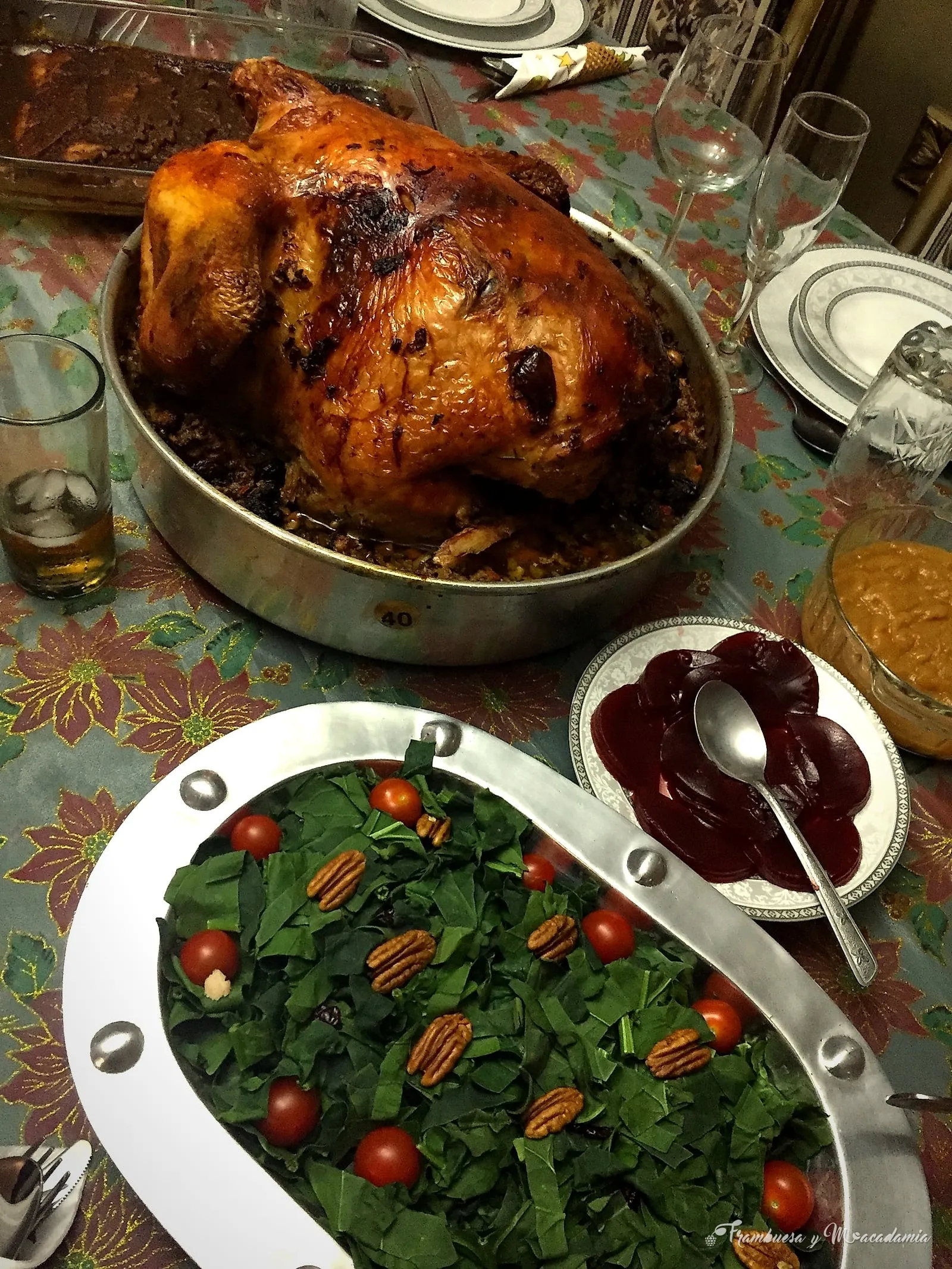 Cena navideña servida en mesa: pavo dorado, ensalada verde con nuez y salsa de arándano