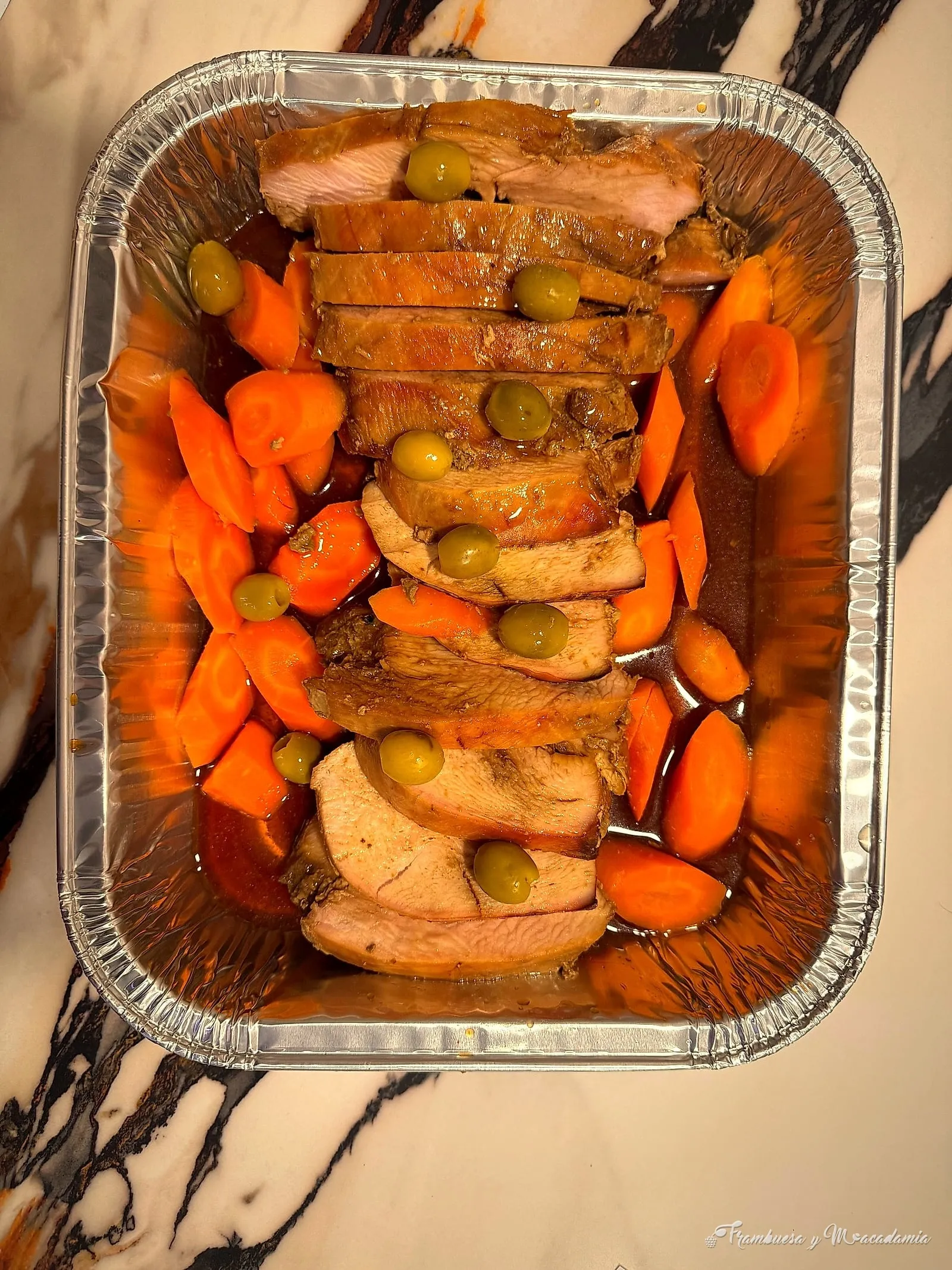Lomo de cerdo rebanado con zanahorias y aceitunas en charola navideña