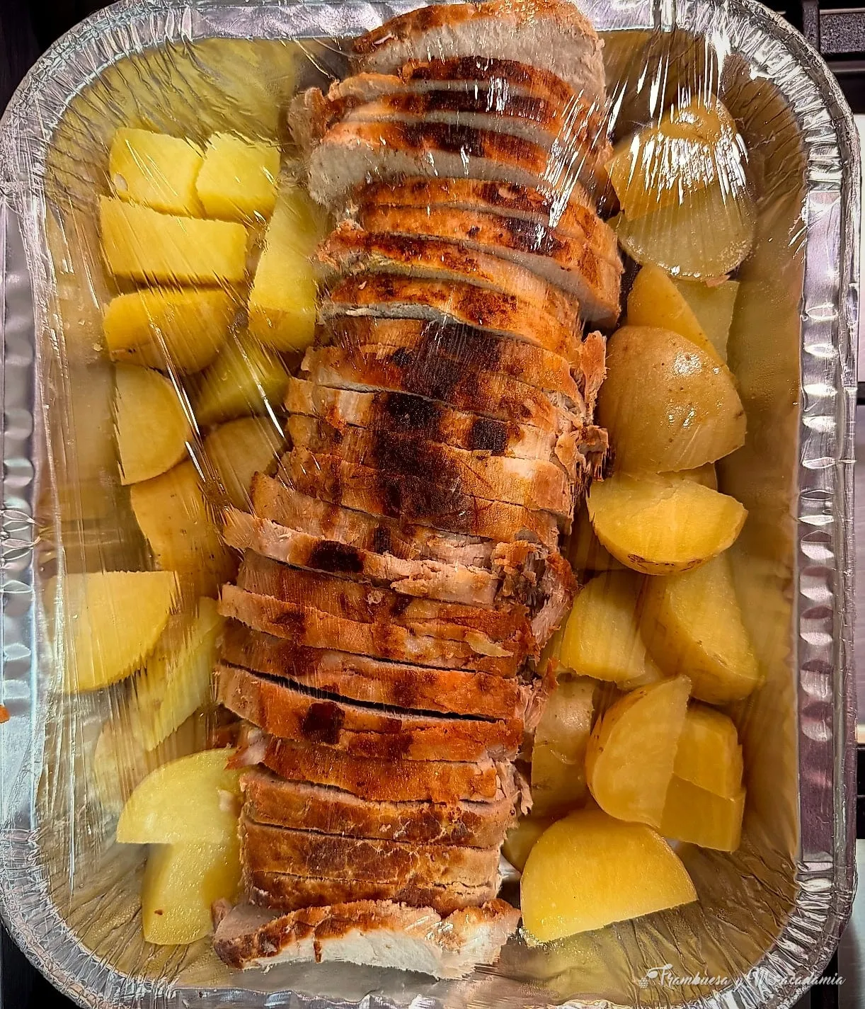 Lomo horneado rebanado con papas en charola, listo para entregar