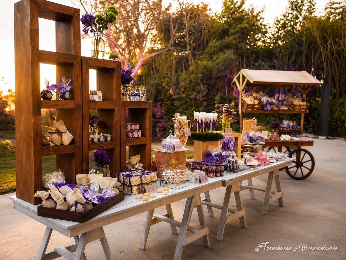 Mesa de dulces en tonos morados montada en jardín