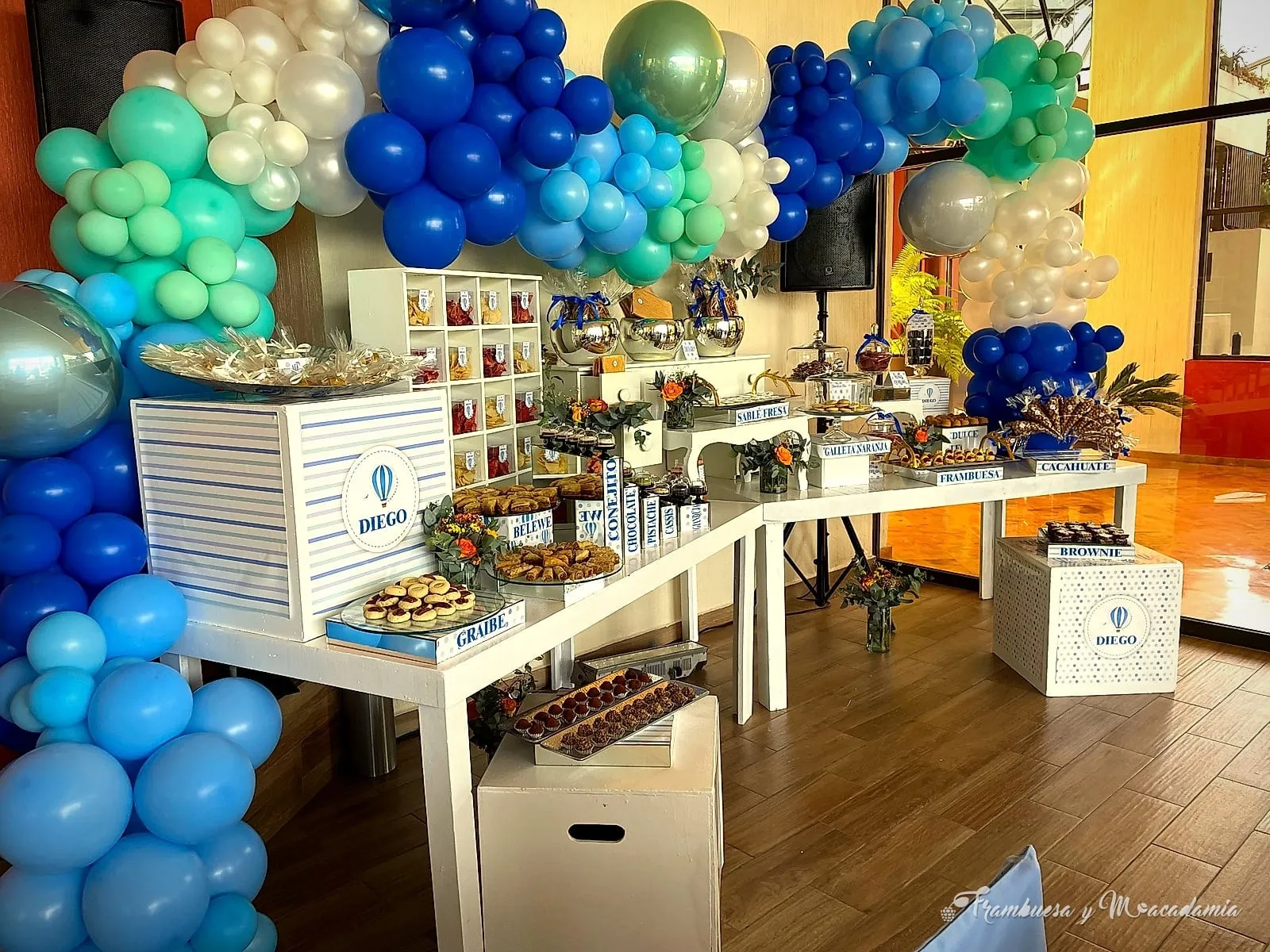 Mesa de postres para fiesta infantil con globos en tonos azules