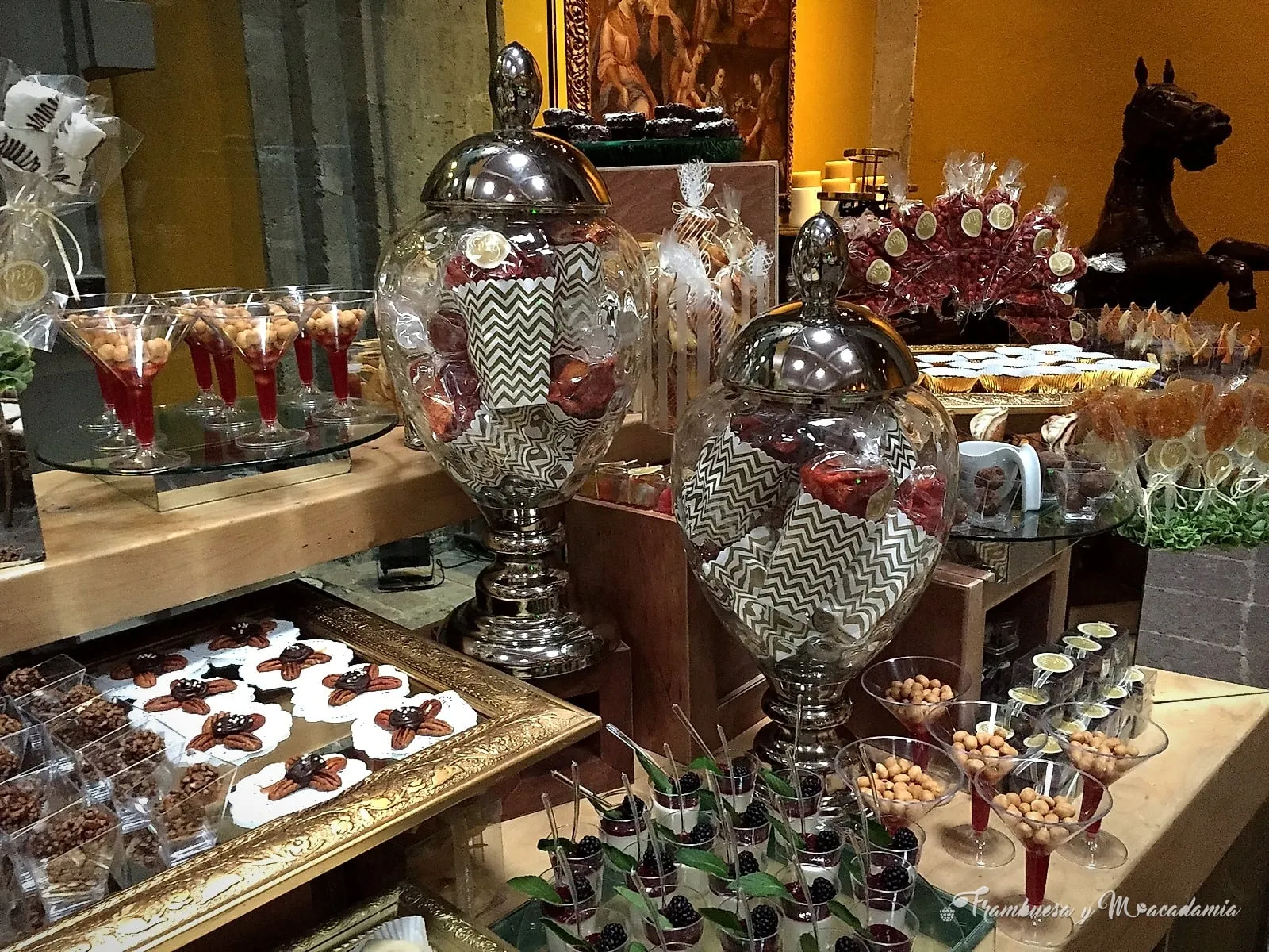 Mesa de postres con cristalería y detalles dorados en salón