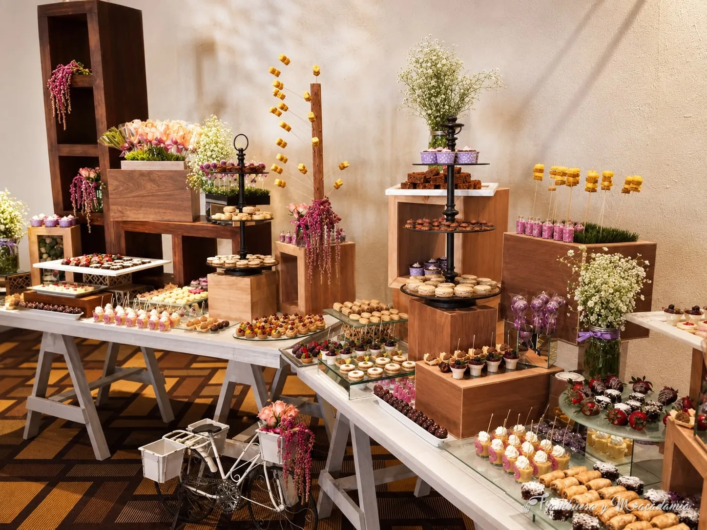 Mesa de postres y dulces libaneses en boda con flores moradas