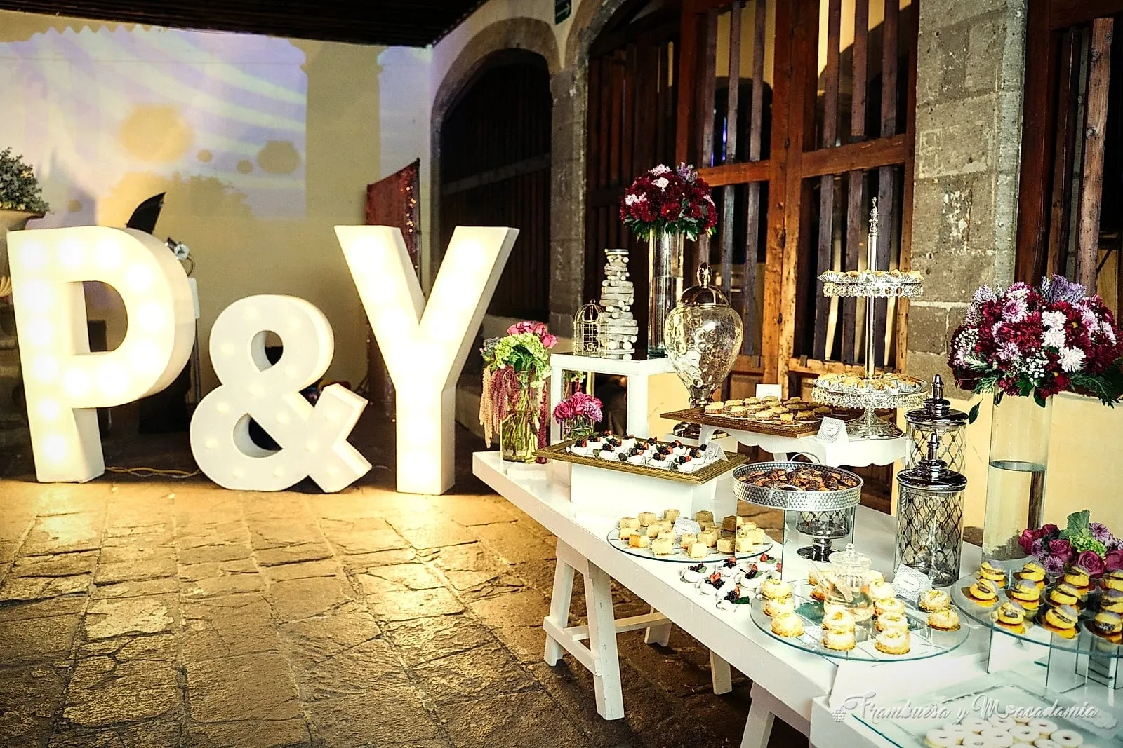 Mesa de postres en boda con letras luminosas personalizadas