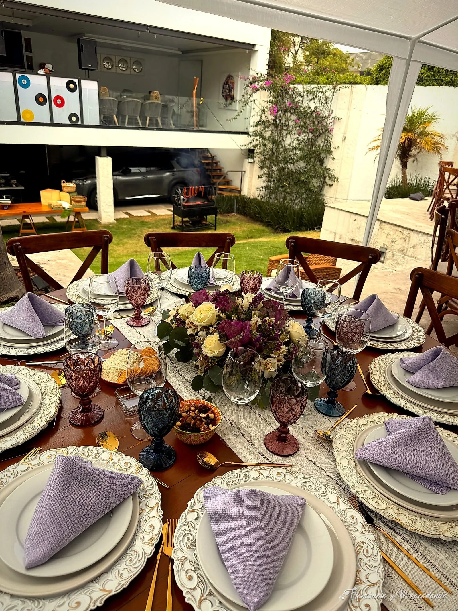 Mesa puesta con vajilla, copas y flores para banquete de 3 tiempos